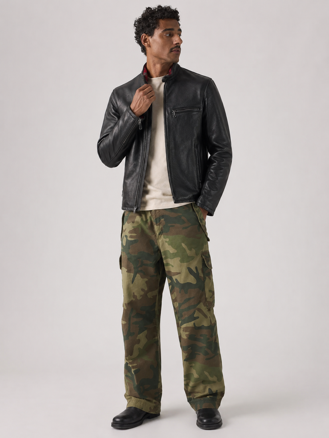 Man wearing black leather jacket and camouflage cargo pants for stylish casual look