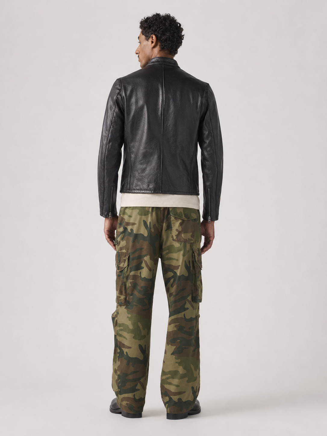 Men's black leather jacket with camouflage cargo pants, back view