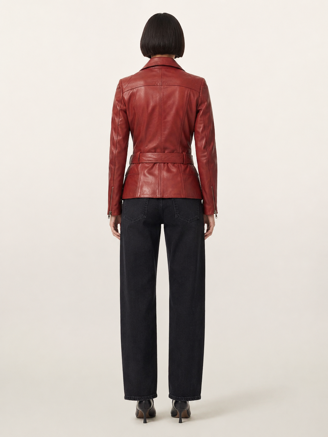 Red leather jacket with belt back view, paired with black wide-leg jeans and heels
