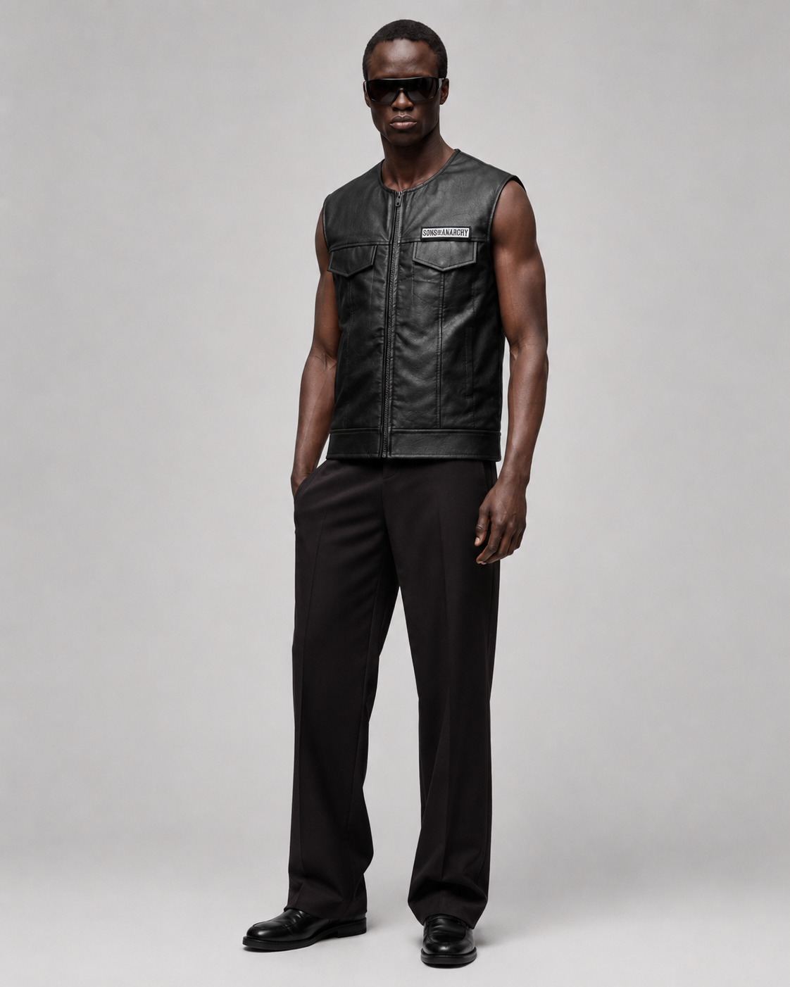 Men's black leather vest with Sons of Anarchy patch, styled with black pants and sunglasses