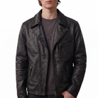 Men's distressed black leather moto jacket with zippered pockets and collar detail