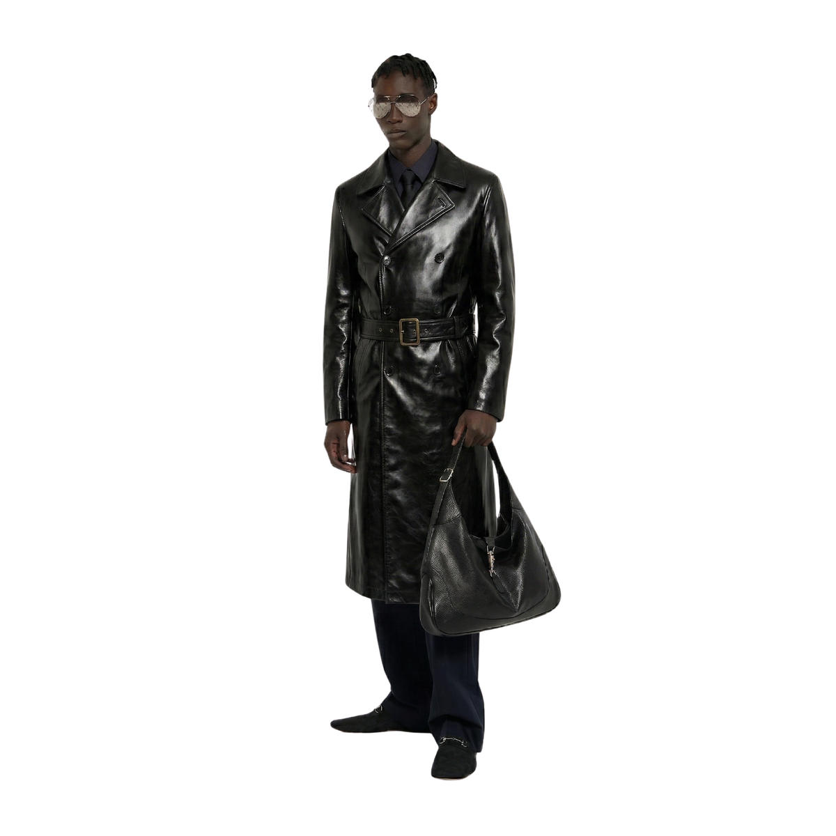 Man in sleek black leather trench coat with belt, holding matching bag, stylish urban look