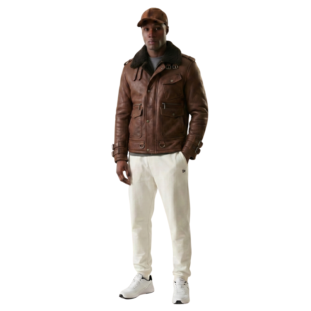 Man wearing brown leather jacket with shearling collar, white pants, and sneakers