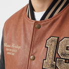 Brown leather varsity jacket with CH buttons, striped collar, and embroidered 'Classic Heritage' text