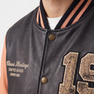 Black leather varsity jacket with embroidered '19' and 'Classic Heritage' text, gold CH buttons, striped collar