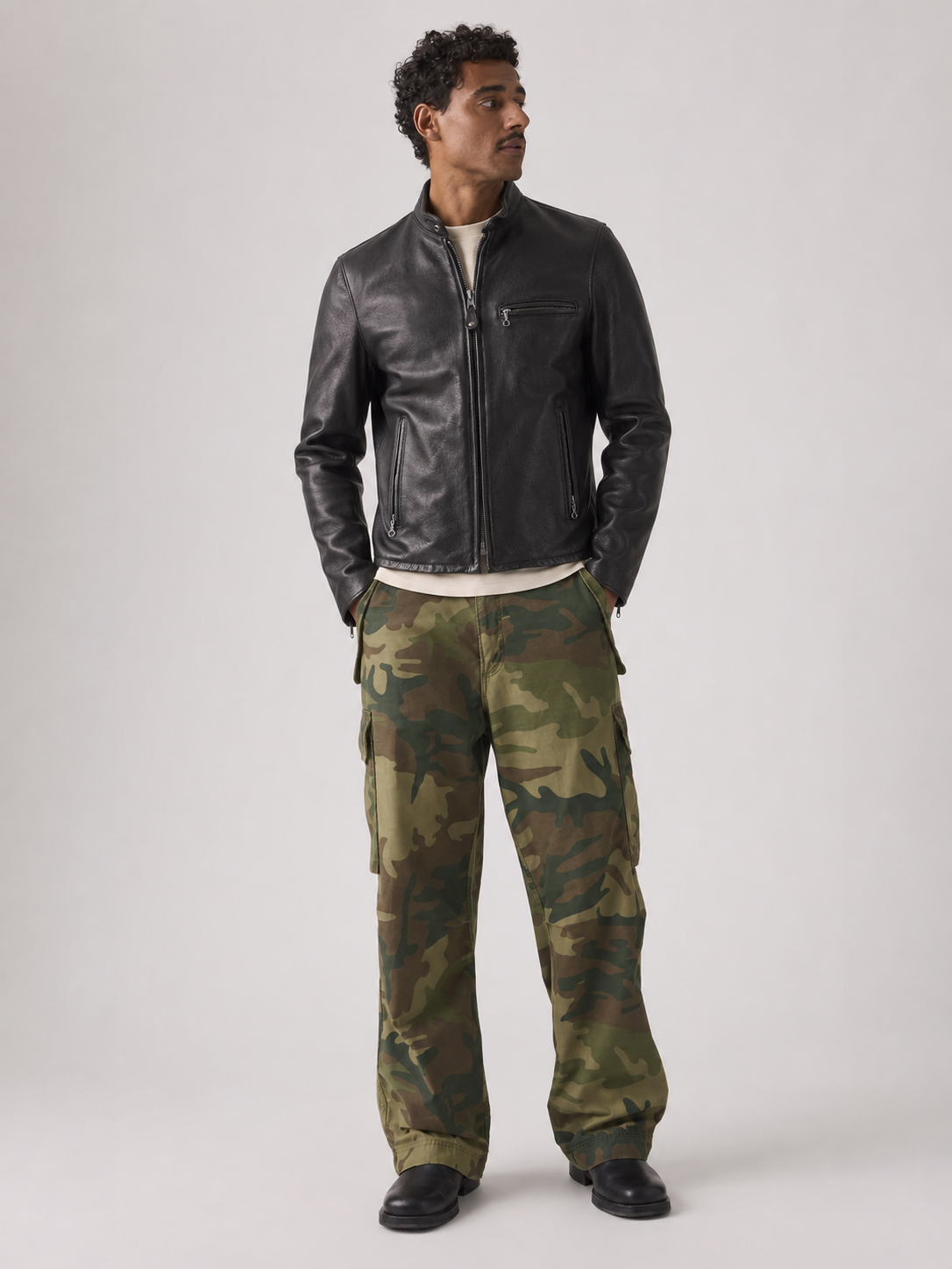 Man wearing black leather jacket and camouflage cargo pants for stylish casual wear