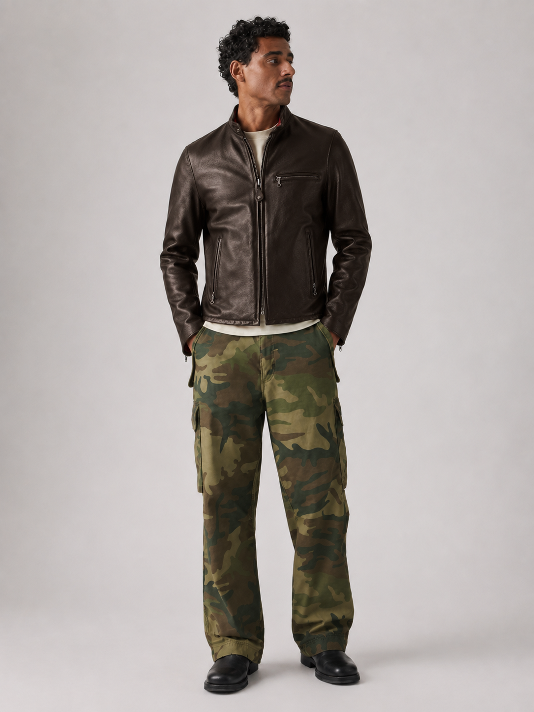 Man wearing brown leather jacket and camouflage cargo pants for stylish outdoor look