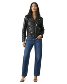 Woman wearing black leather moto jacket with belt, blue jeans, and heels