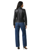 Woman wearing black leather moto jacket with zipper details, paired with wide-leg blue jeans and heels