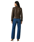 Woman wearing brown leather jacket and blue wide-leg jeans, back view