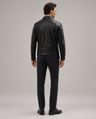 Man wearing black leather jacket and slim-fit trousers, back view