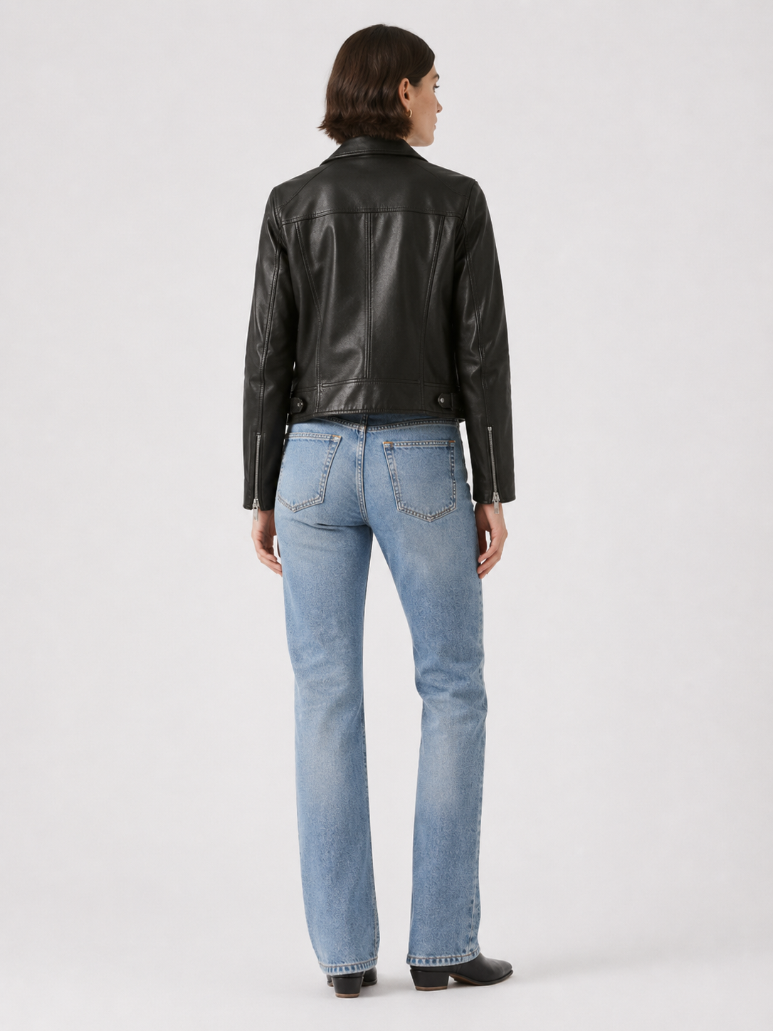 Black leather jacket with blue jeans, back view, stylish casual outfit