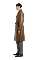 Men's brown leather trench coat with belt, styled with beanie and gray trousers