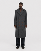 Men's gray double-breasted wool coat with patterned texture, worn with dark trousers and loafers