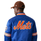 Blue Mets varsity jacket with orange script logo, striped sleeves, and team patch, worn with brown cap