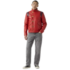 Man wearing red leather jacket with gold buckles, gray jeans, and black sneakers