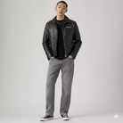 Men's black leather jacket with zipper, paired with gray jeans and sneakers for casual streetwear style