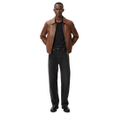 Man wearing brown leather jacket, black tee, and wide-leg jeans for casual style
