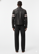 Men's black leather moto jacket with white red stripe sleeves, back view, paired with dark jeans