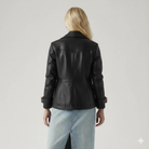 Black leather jacket with gold buckle cuffs, back view on model with blonde hair