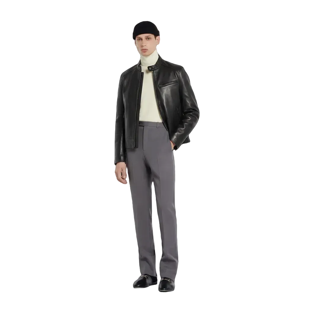 Man wearing black leather jacket, gray trousers, and black loafers with white turtleneck