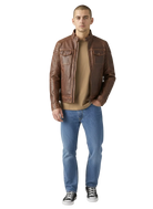 Man wearing brown leather jacket with chest pockets, blue jeans, and black sneakers