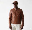 Men's brown leather jacket with zip pockets, styled with cap and white pants