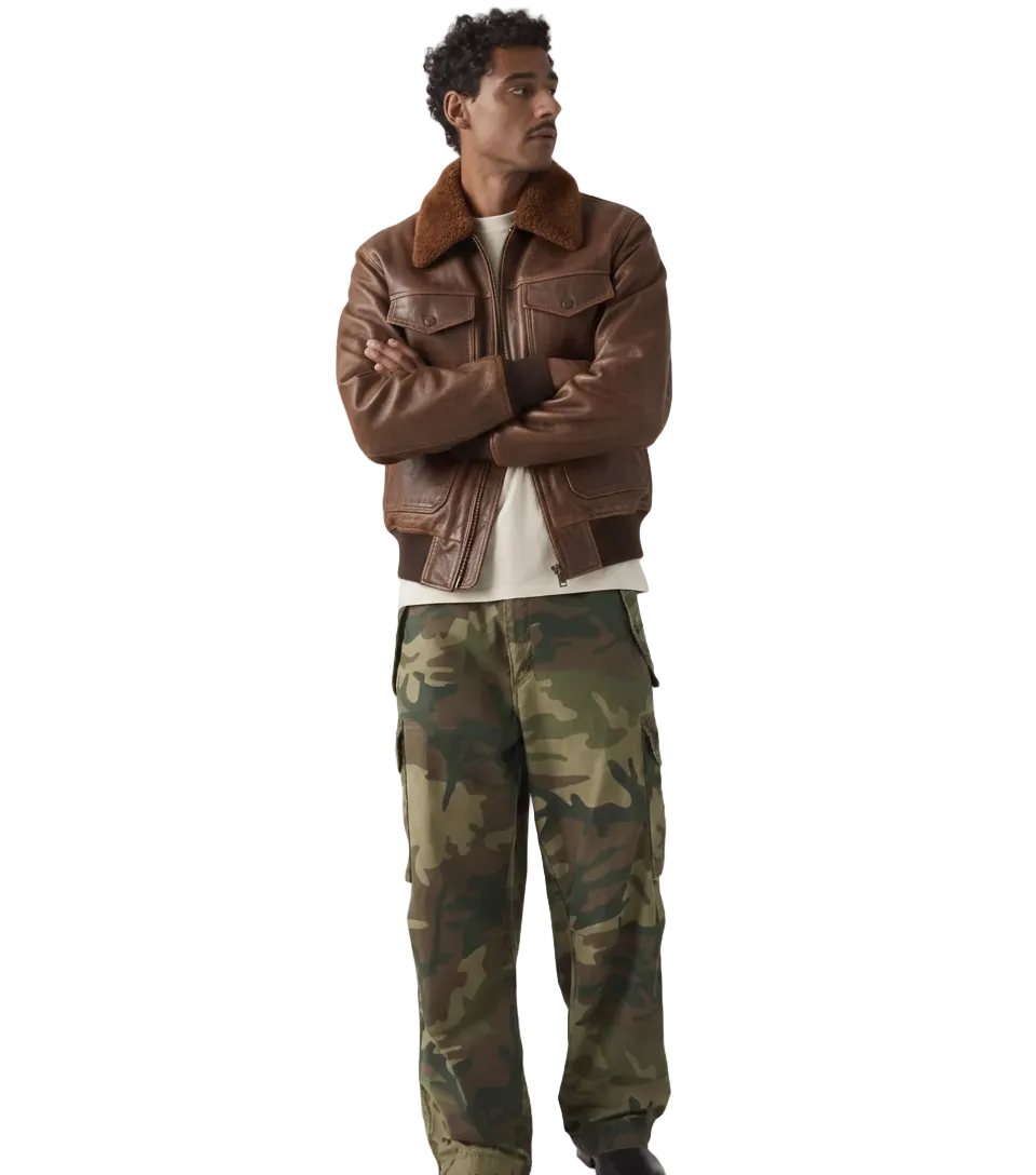 Men's brown leather bomber jacket with shearling collar paired with camouflage cargo pants