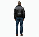 Men's black leather bomber jacket with shearling collar, back view, paired with blue jeans