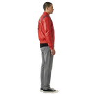 Man wearing red leather bomber jacket with patch, gray jeans, and black sneakers, side view