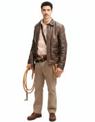 Man in vintage brown leather jacket, beige shirt, and khaki pants holding coiled rope, rugged outdoor style