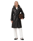 Black leather trench coat with belt, paired with white pants and sneakers, holding a brown bag