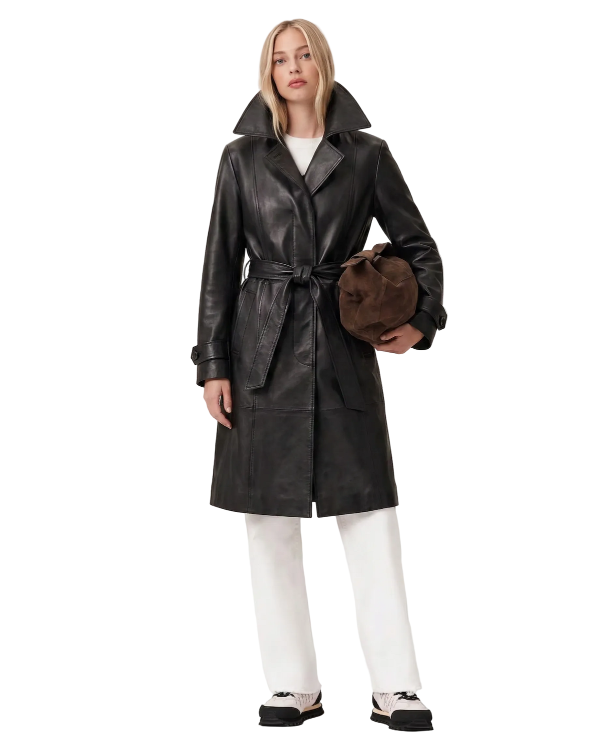 Black leather trench coat with belt, paired with white pants and sneakers, holding a brown bag