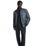Man wearing stylish navy blue leather jacket with ribbed collar and front pockets, paired with dark pants.