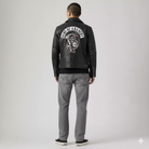 Men's black leather jacket with Sons of Anarchy back patch, paired with gray jeans and sneakers