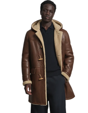 Men's brown leather duffle coat with shearling lining and toggle closure, styled over a dark sweater.