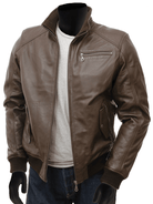 Brown leather bomber jacket with zipper pockets and ribbed cuffs, styled over gray tee and jeans