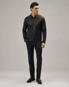 Men's black leather jacket with zipper, paired with slim-fit trousers and dress shoes